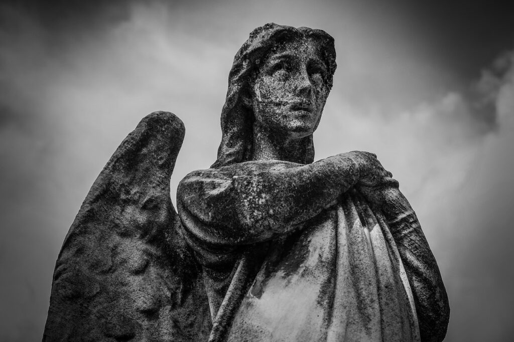 A stone angel statue with wings, photographed in black and white.